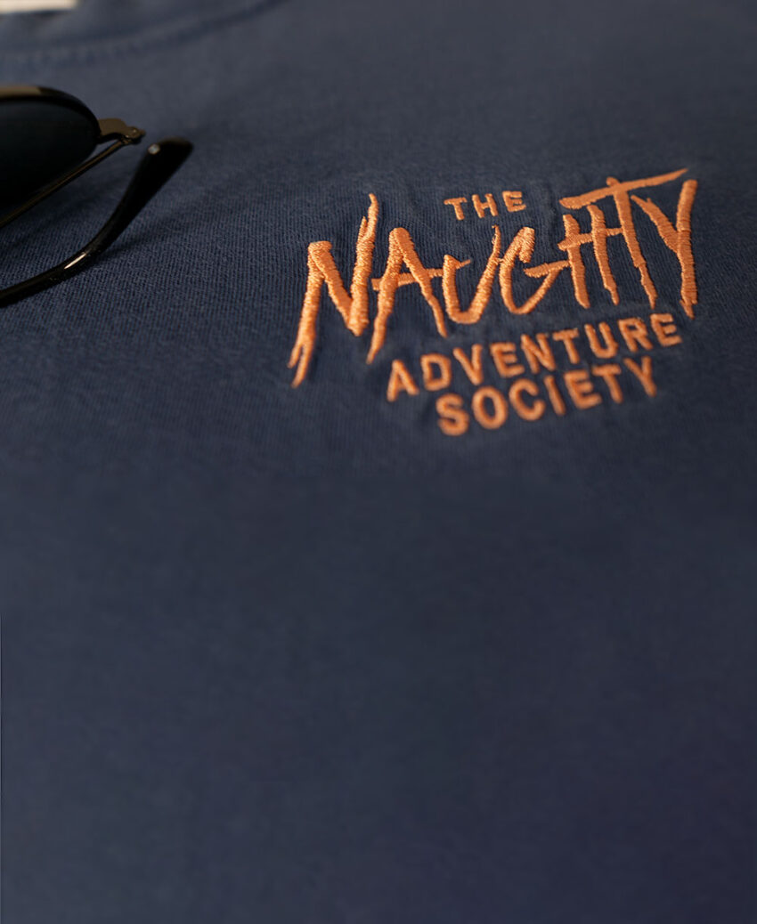 Close-up of the embroidered logo on our midnight peach shirt, featuring our signature playful and edgy aesthetic.