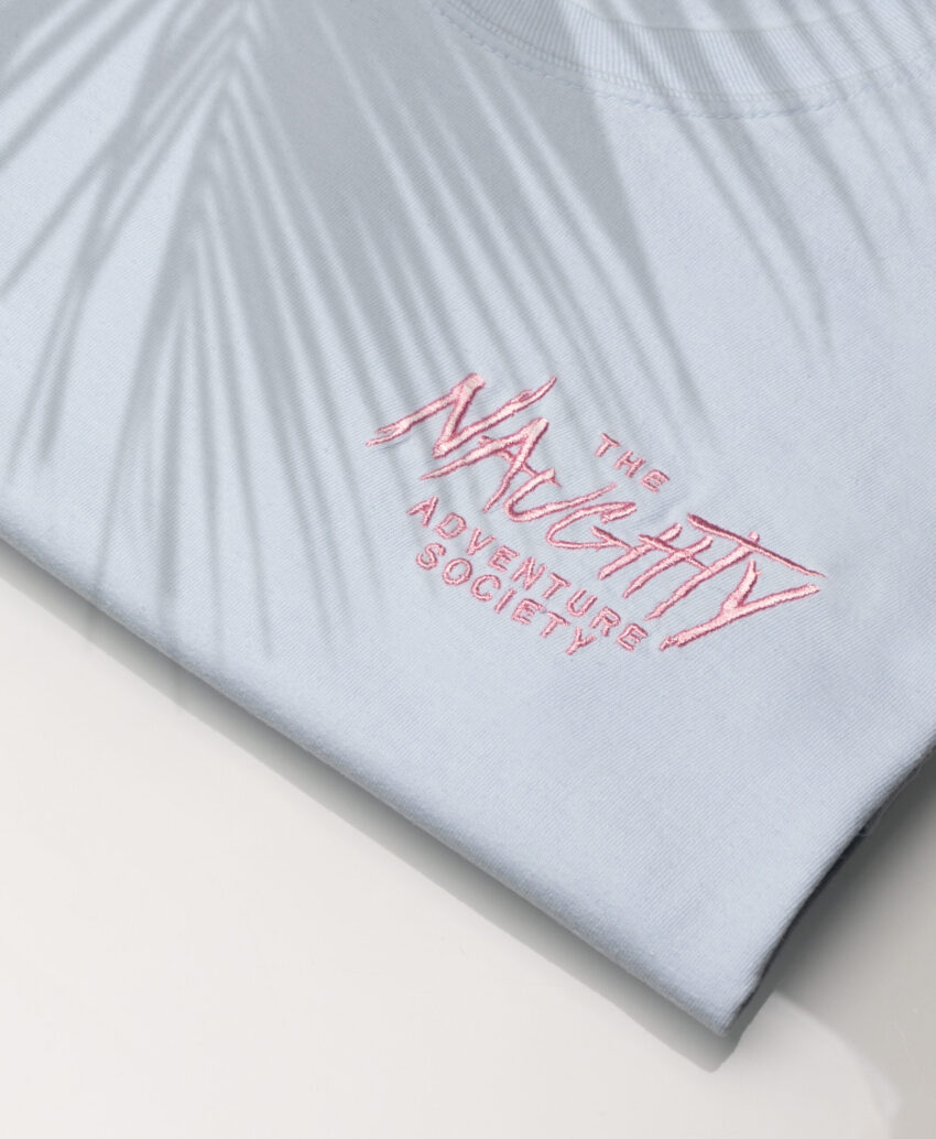 Close up of Chambray Ocean shirt featuring palm drop shadow pattern for your summer vibes.